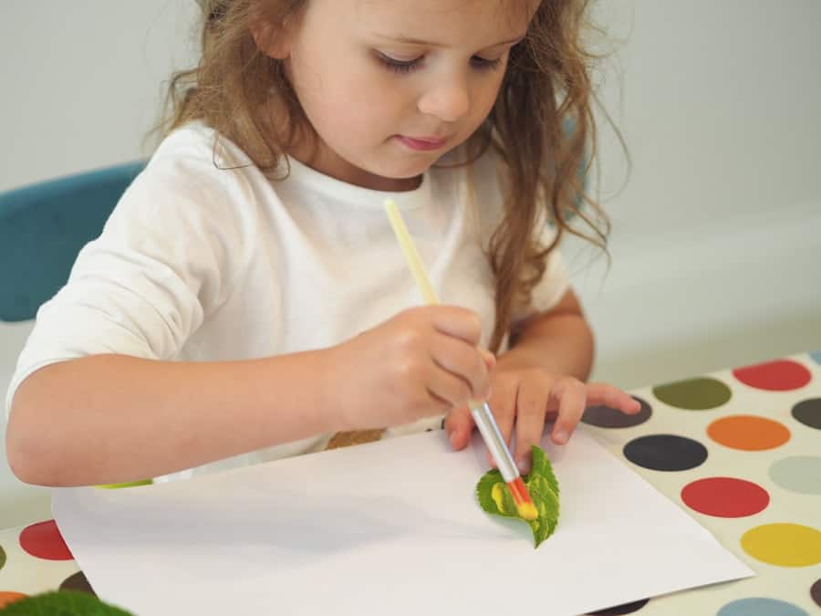 girl painting a leaf